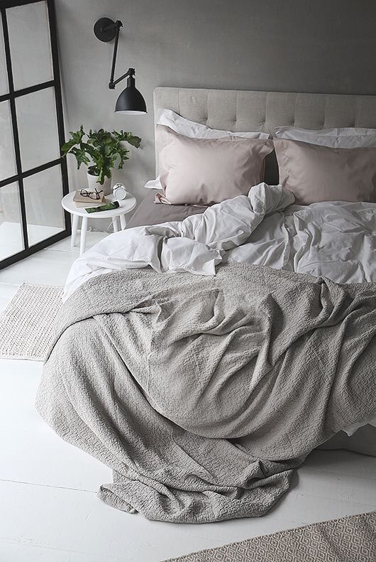 Arredare camera da letto moderna con coperte, lenzuola, traverse e cuscini