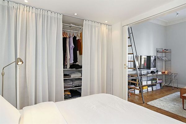 piccola camera da letto con armadio chiuso con tende