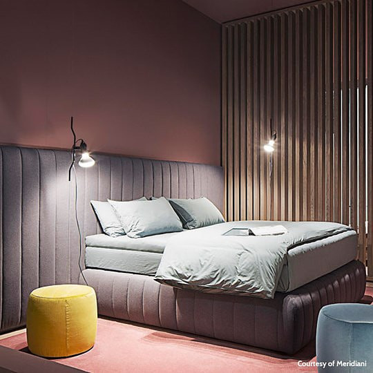 Una camera da letto con un letto e un tavolo con sopra una lampada.